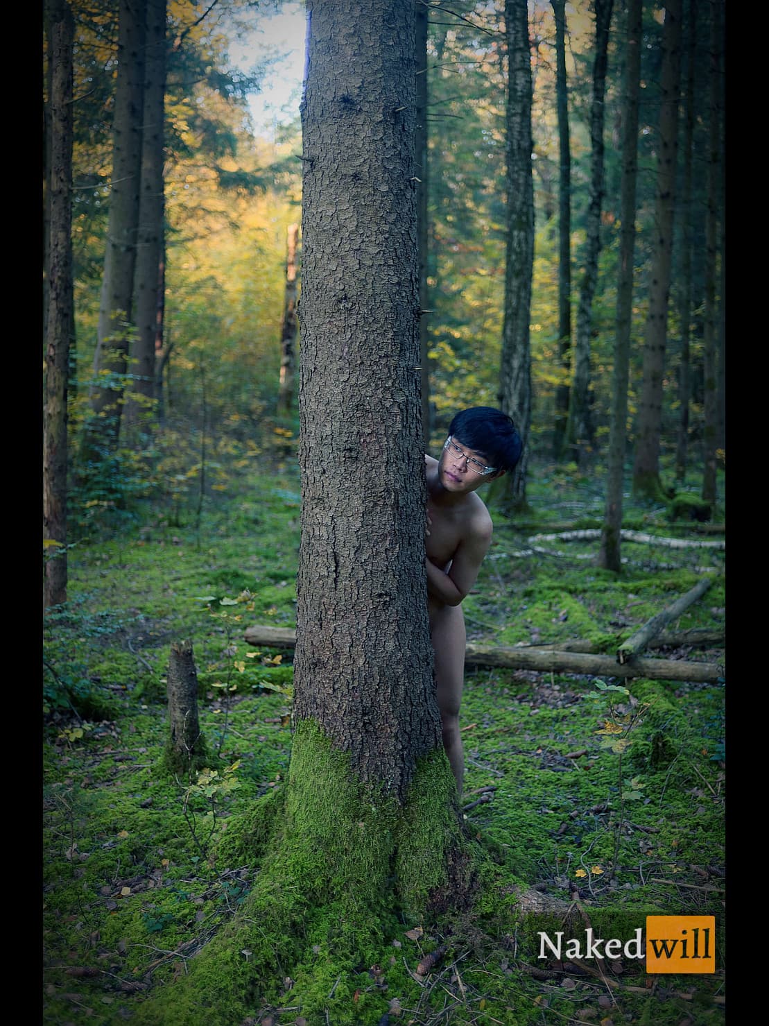 A young man with glasses stands nude in a lush, moss-carpeted forest, partially concealed by a towering tree as he gazes curiously at the viewer. The image evokes a poetic blend of human vulnerability and deep connection with the natural world.